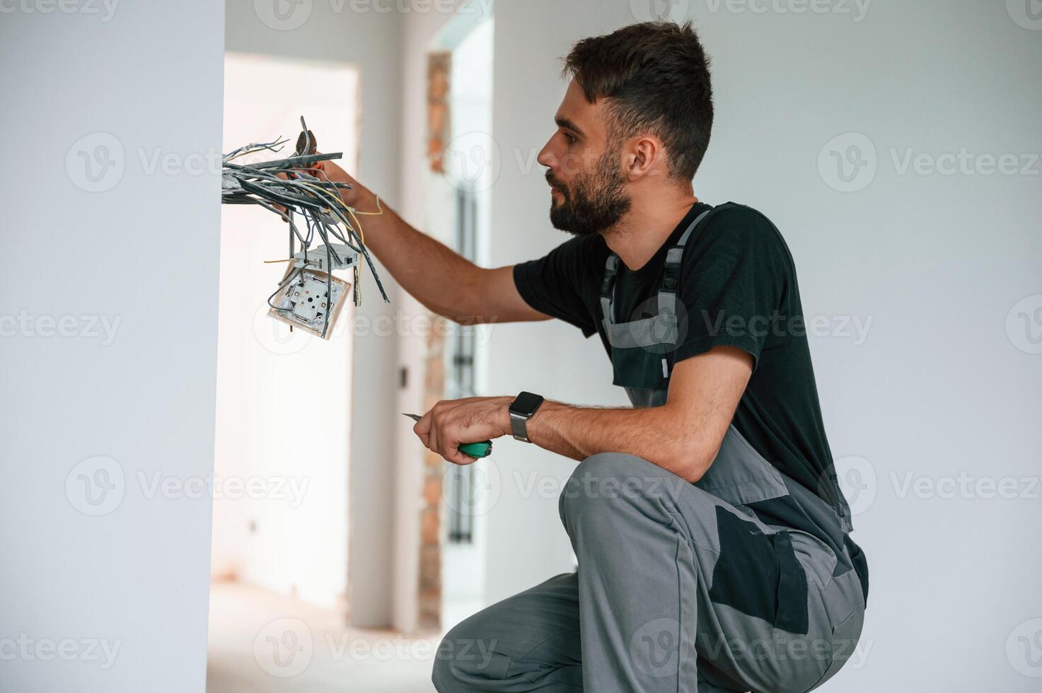 Electrician ,is working with wires indoors in the room photo