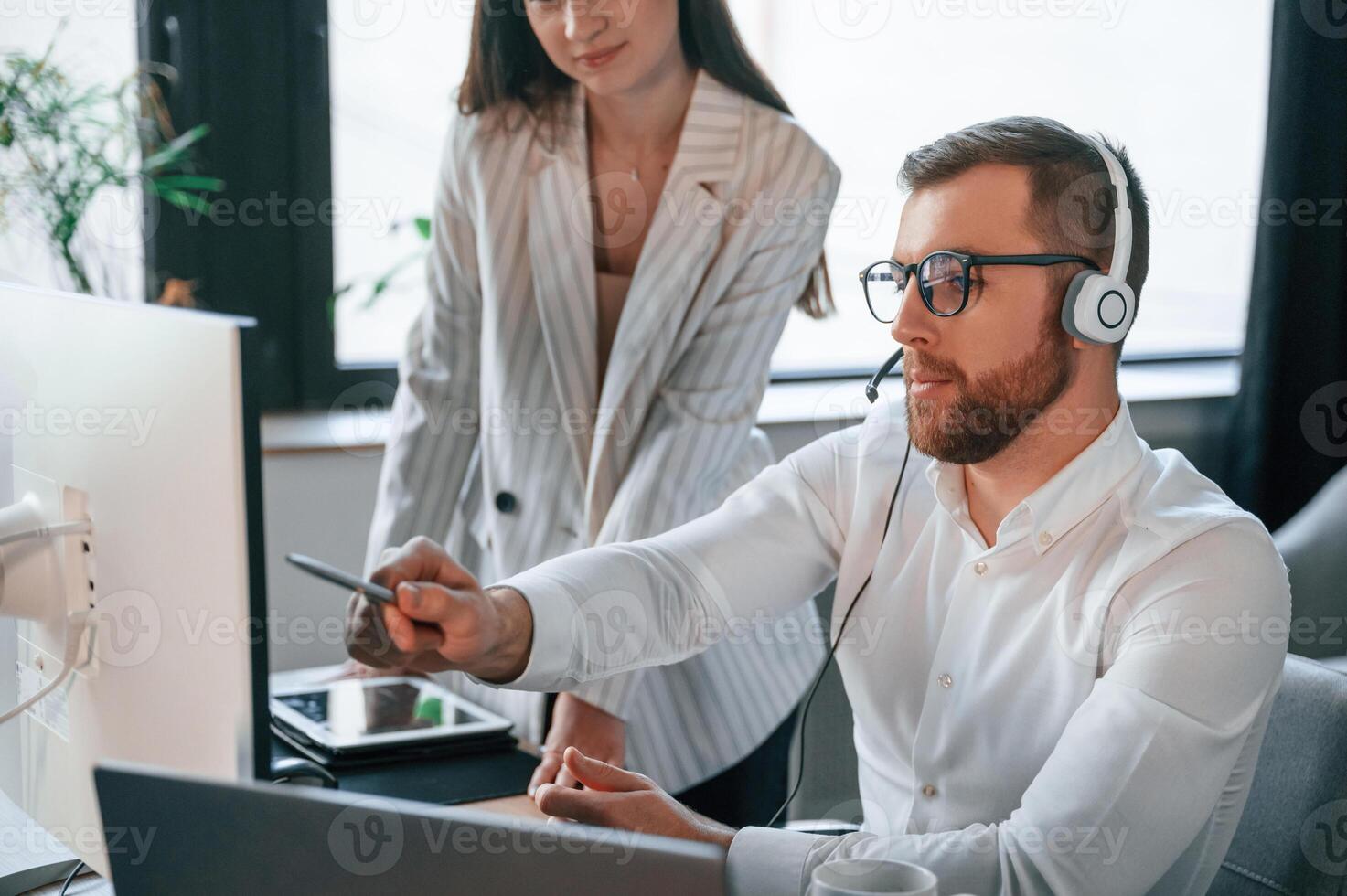 Analyzing ,information that is ,on the screen. Two employees are working together in the modern office photo