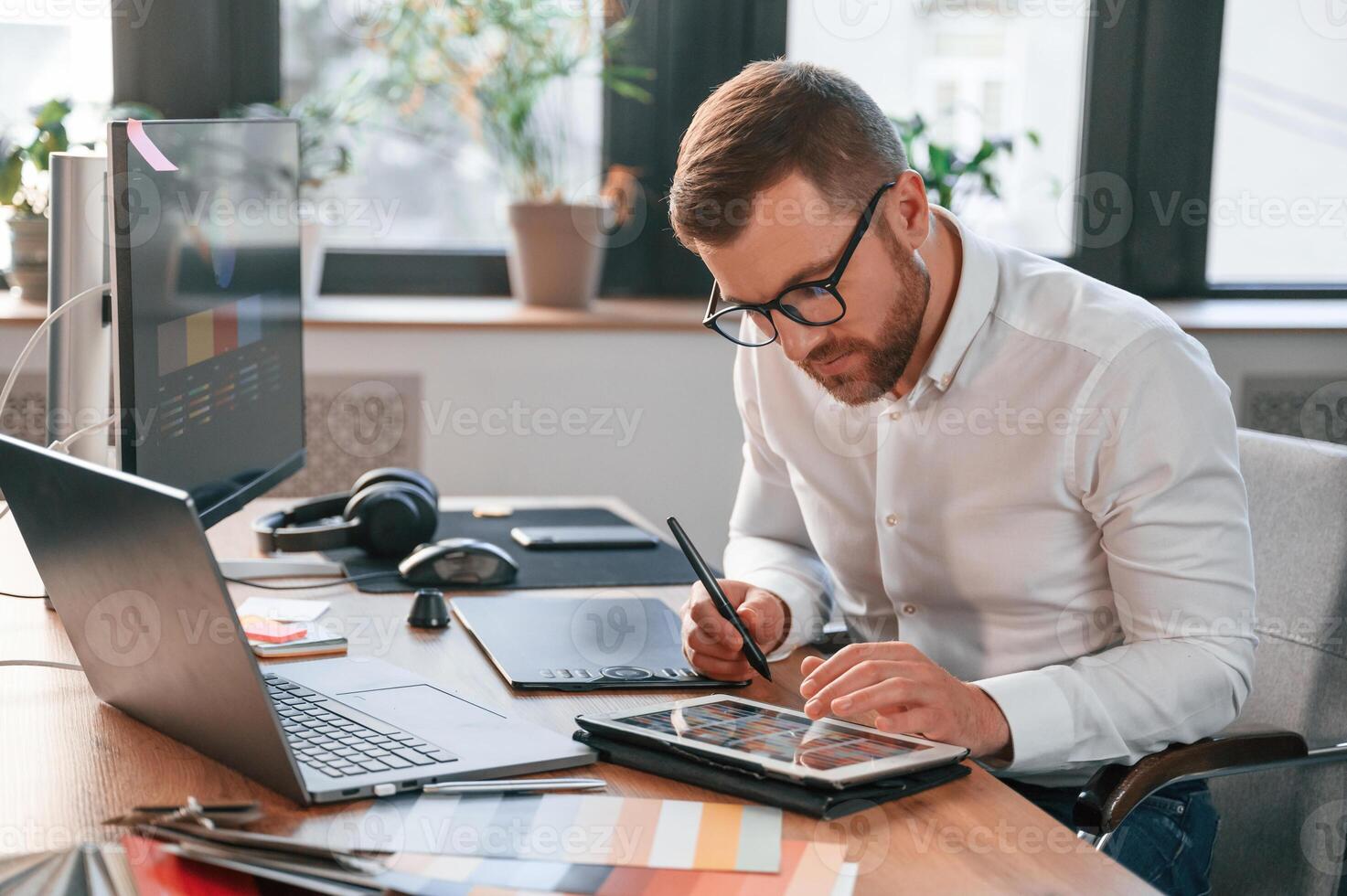 Using tablet. Man in formal ,clothes is working in the modern office photo