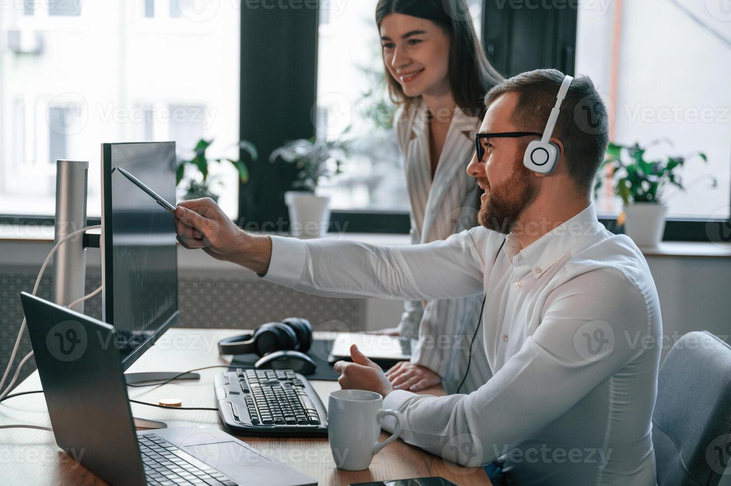 Analyzing information that, is on the screen. Two employees are working together in the modern office photo
