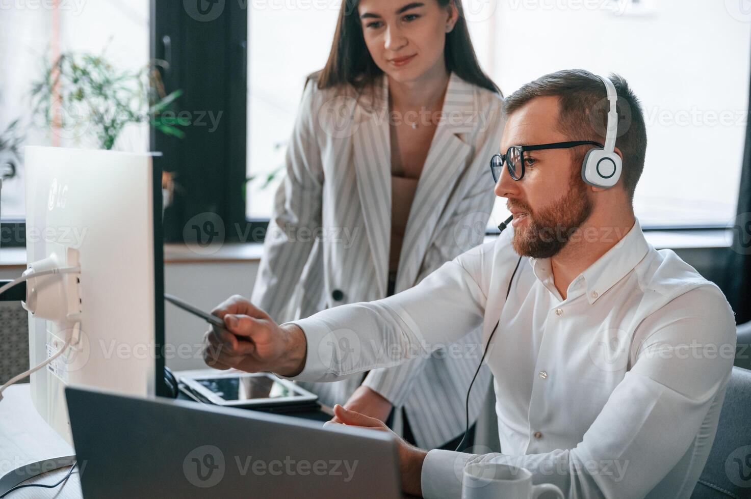 Analyzing, information, that is on the screen. Two employees are working together in the modern office photo