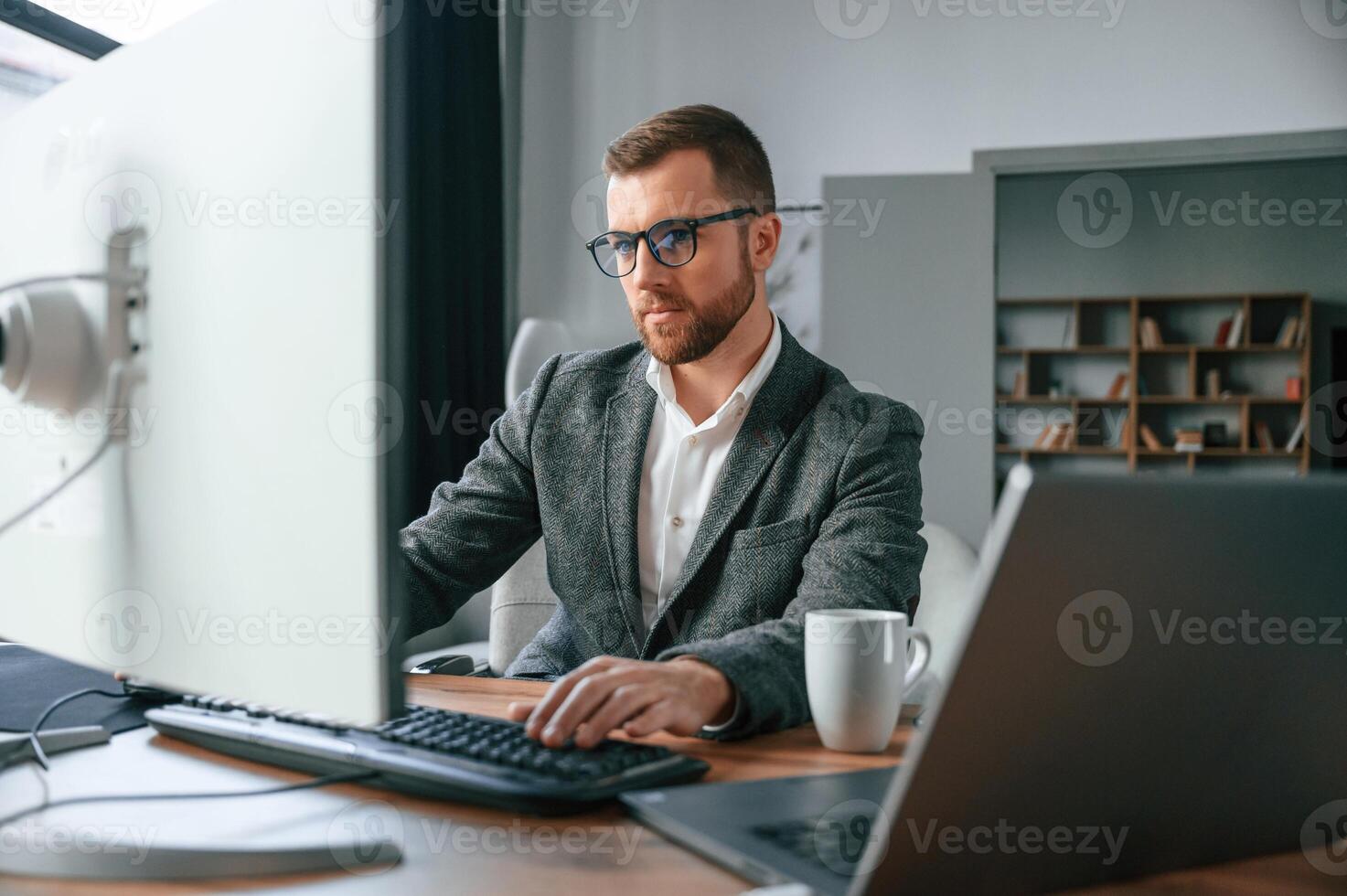 Businessman, in suit is in the office with computer photo