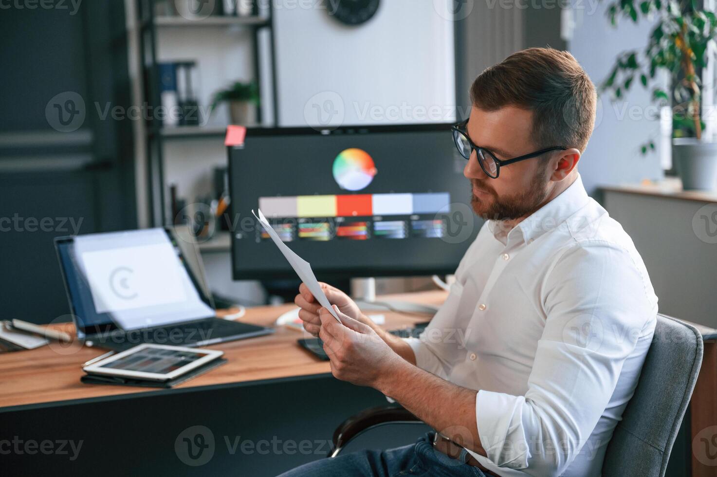 Graphic ,designer is ,sitting. Man in formal clothes is working in the modern office. Using computer photo