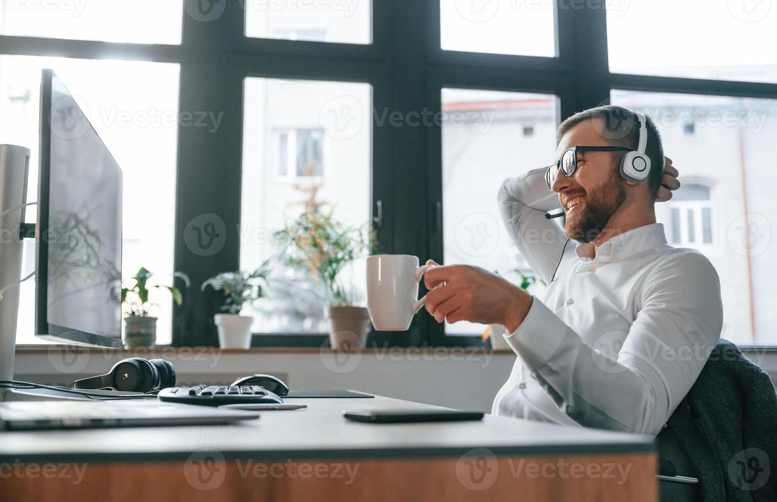 Office worker in formal clothes is sitting by computer and working photo