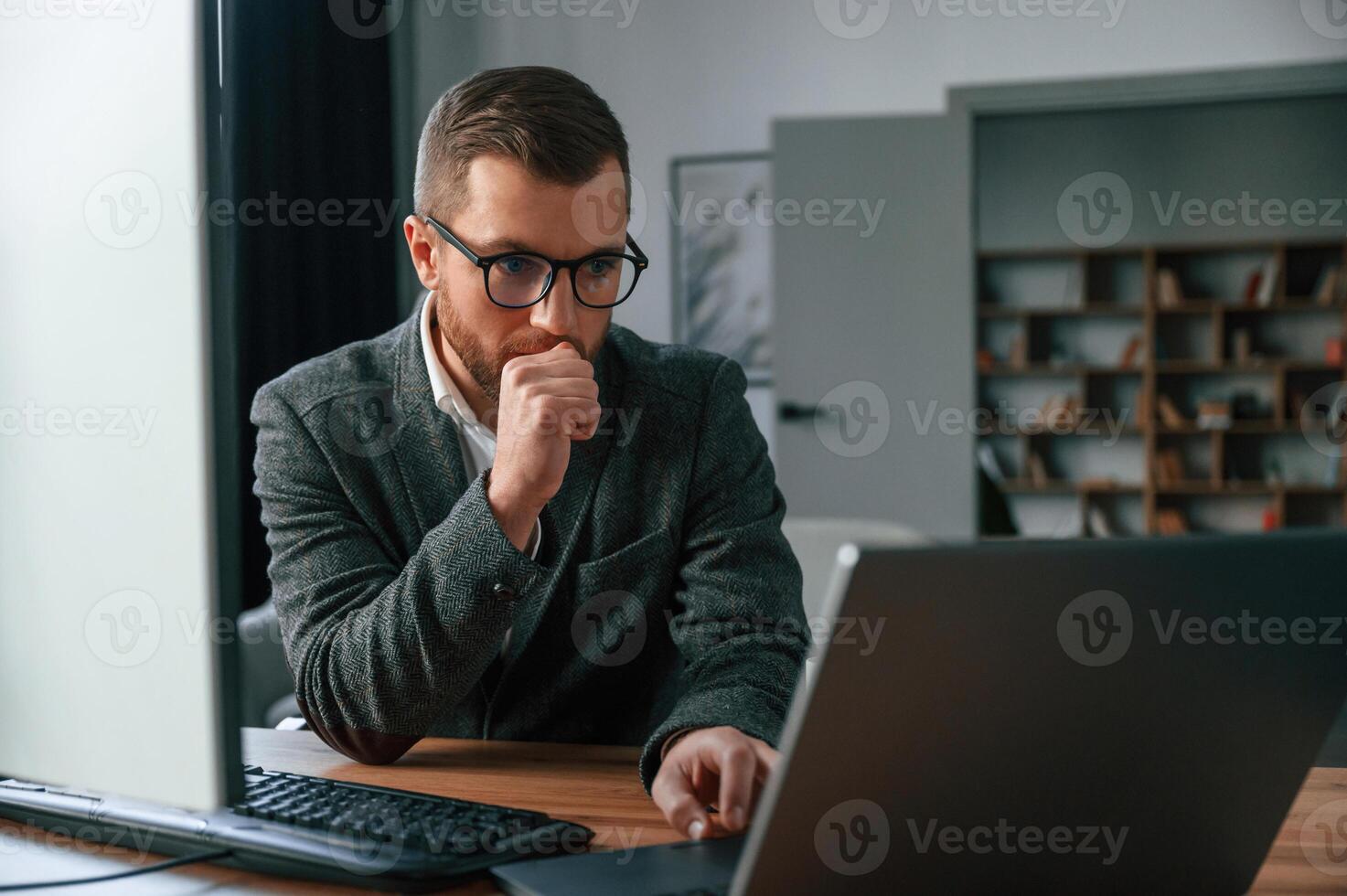 Businessman ,in suit i,s in the office with computer photo