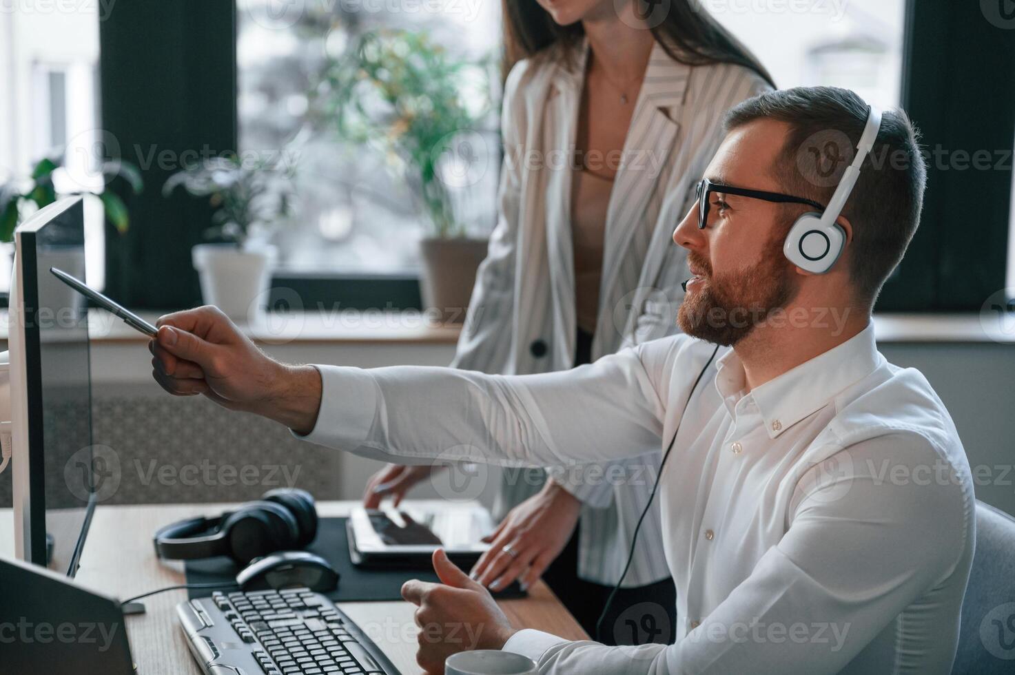 Analyzing information that is on the screen. Two employees are working together in the modern office photo