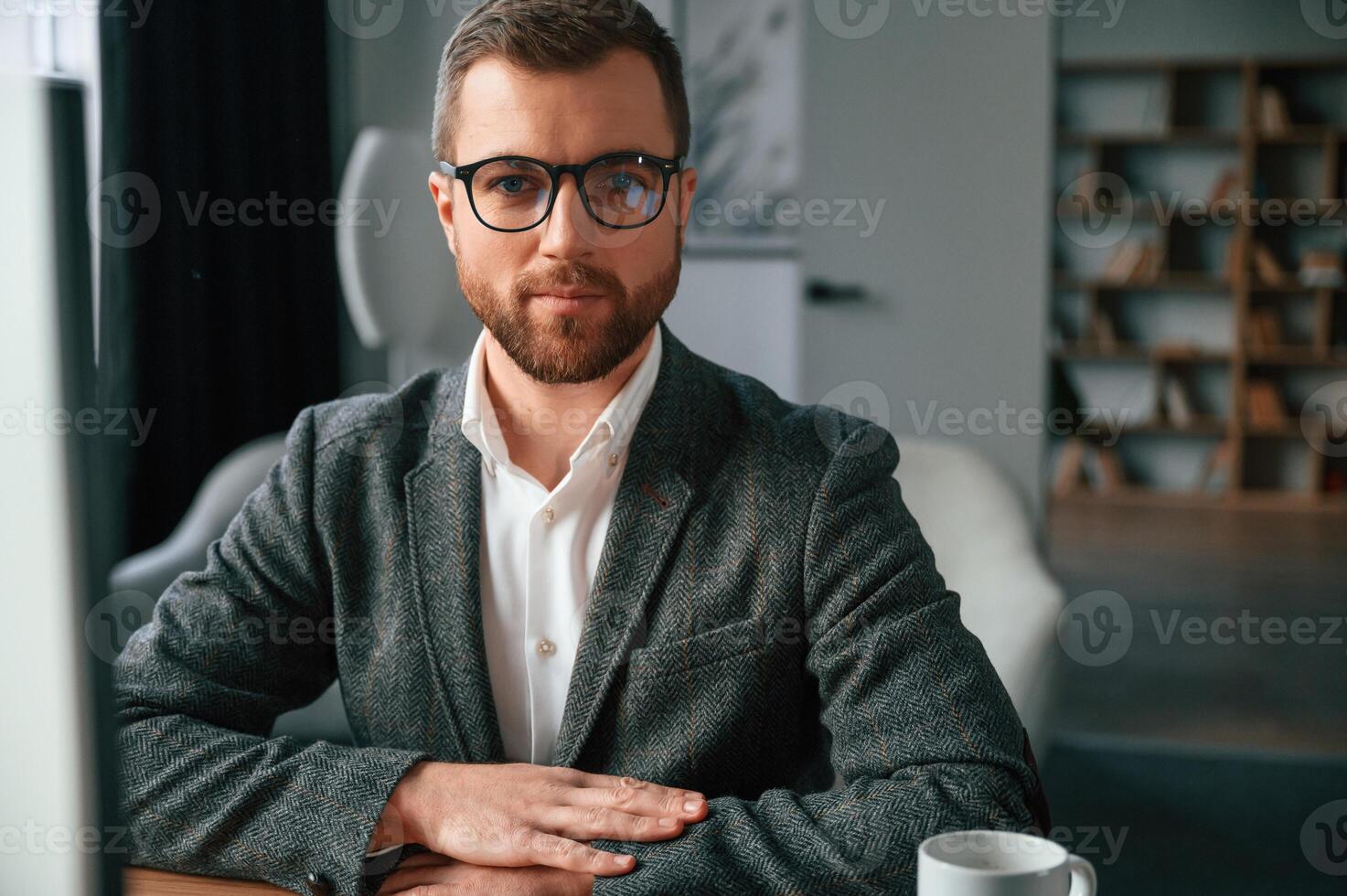 Businessman in suit is in the office with computer., photo