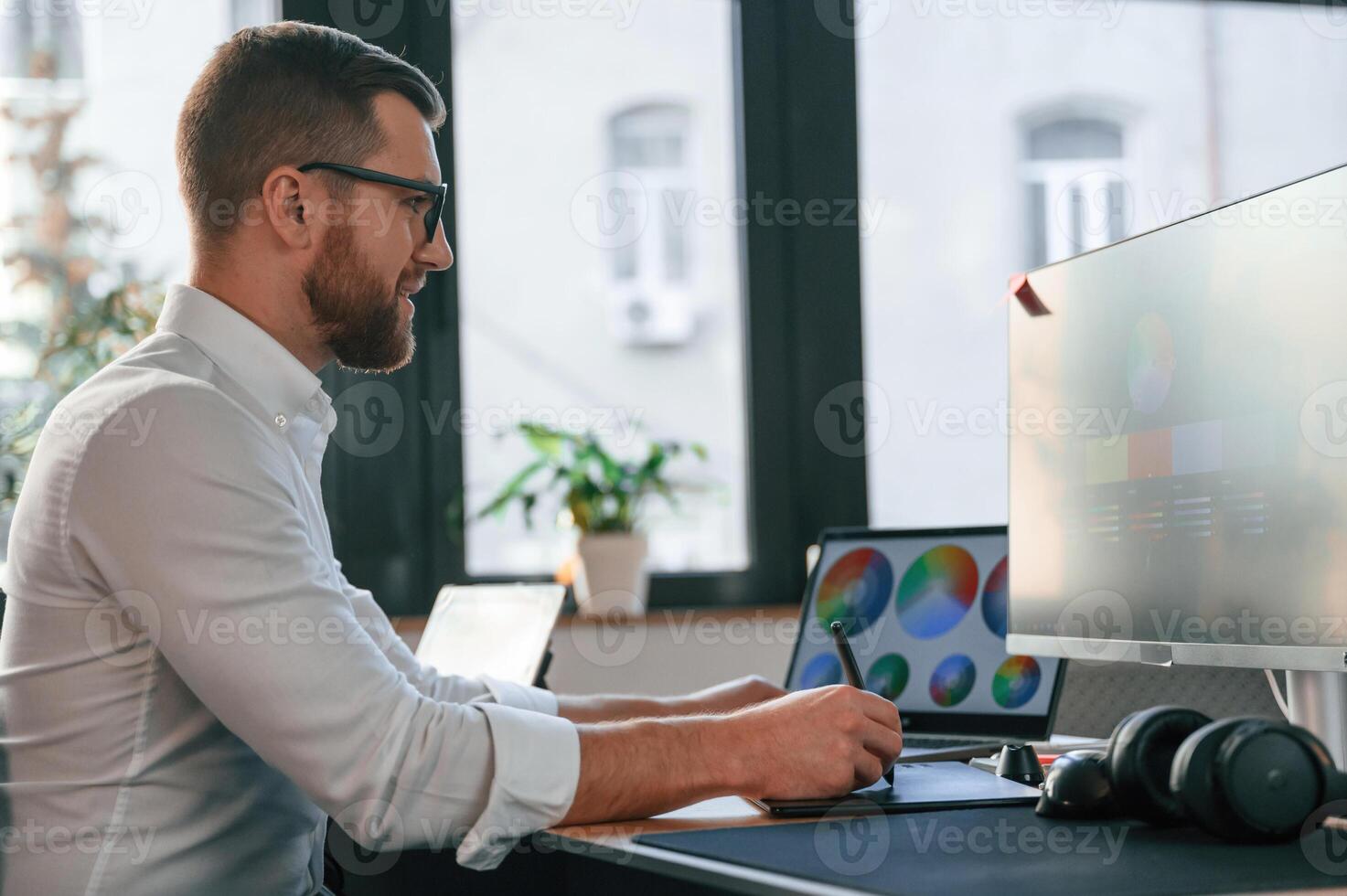 Man in, formal clothes, is working in the modern office. Using computer photo