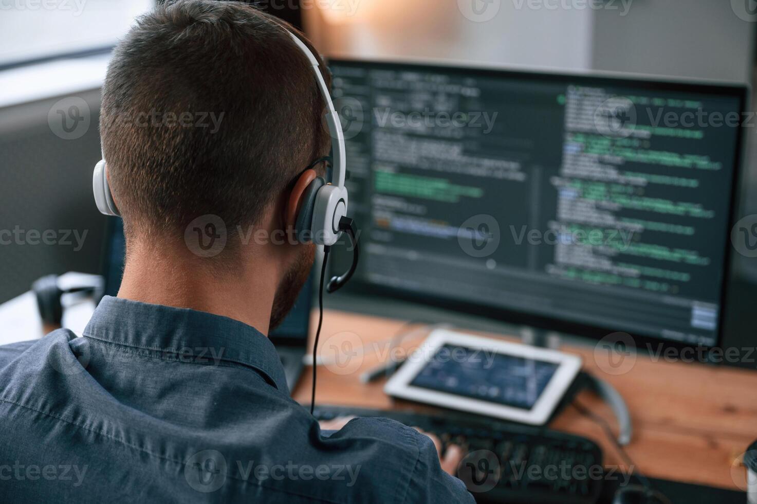 Software ,developer is writing code.. Man in formal clothes is working in the modern office. Using computer photo