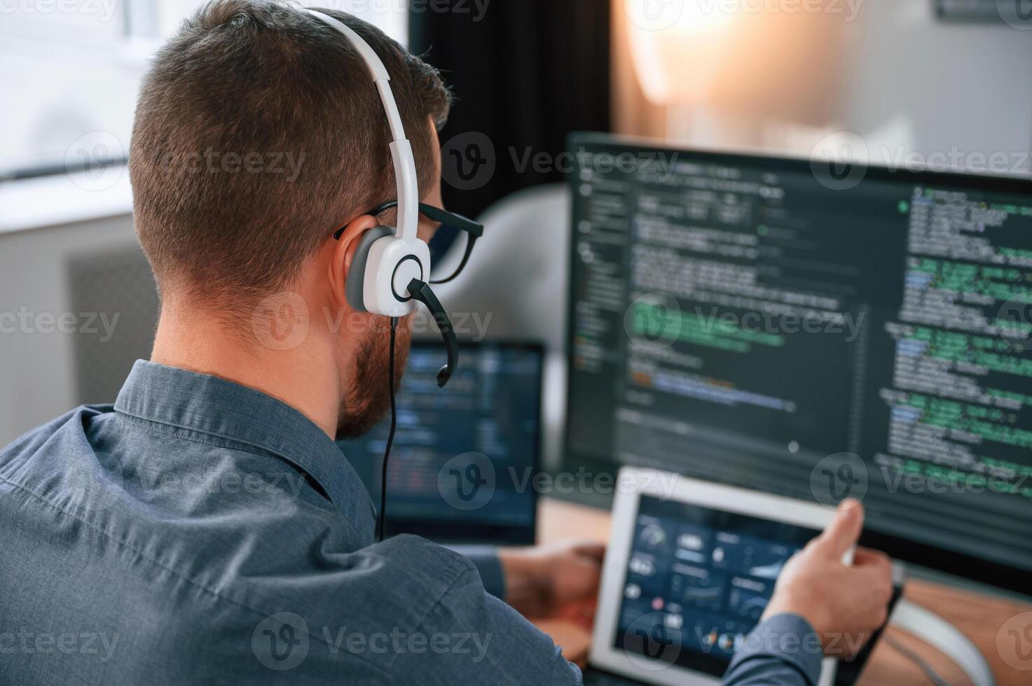 Software, developer is writing code. Man in formal clothes is working in the modern office. Using computer photo