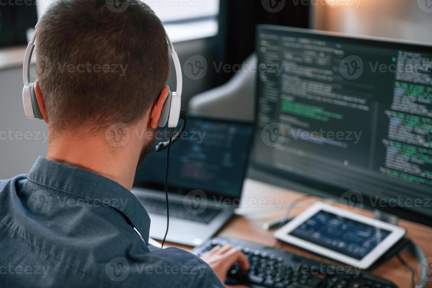 Software developer is,writing code. Man in formal clothes is working in the modern office. Using computer photo
