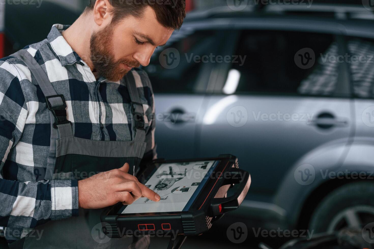 Graphic, information is on the tablet. Man in uniform is working in the auto salon photo