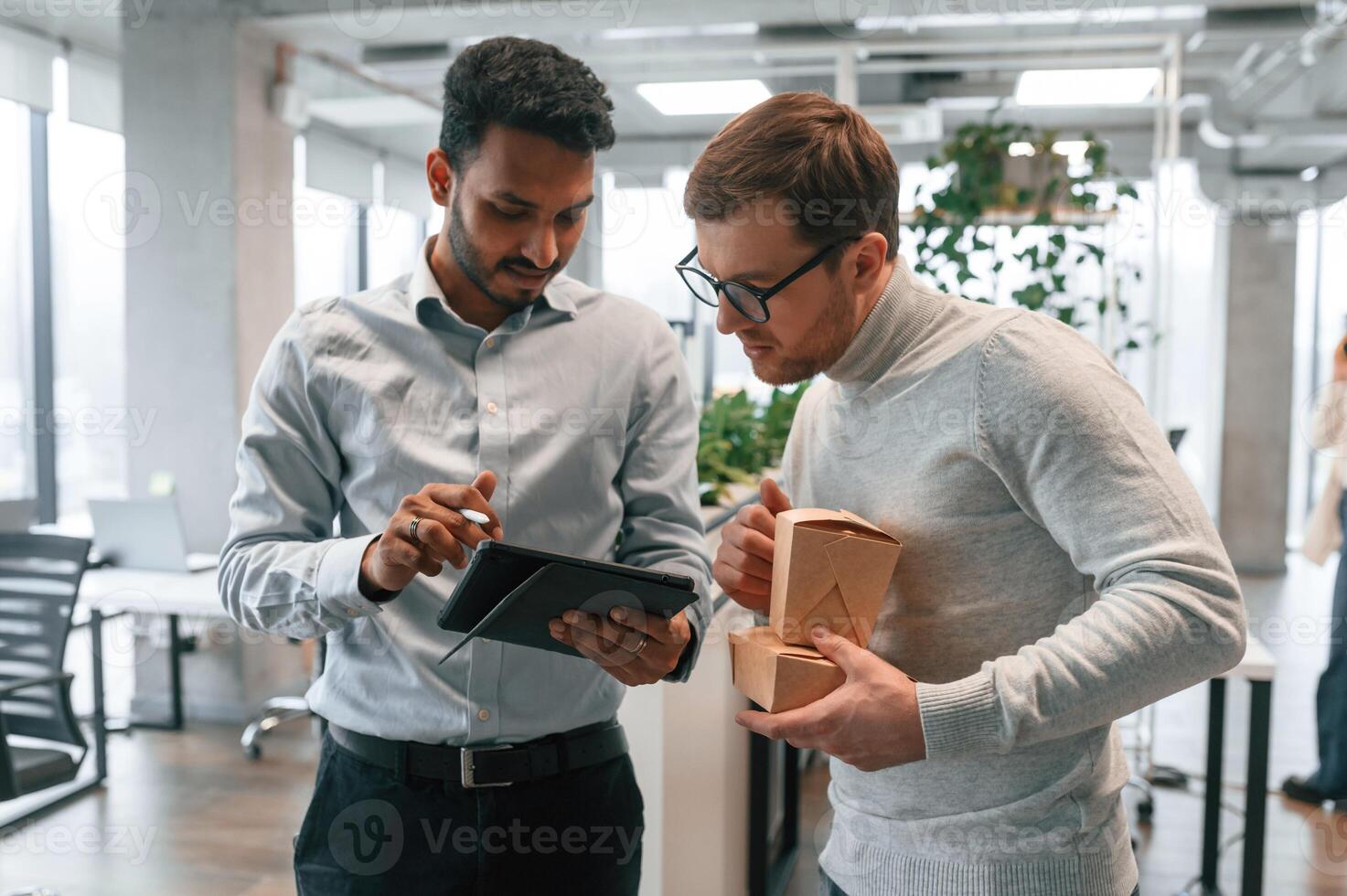 Two men, are working in the modern office together photo