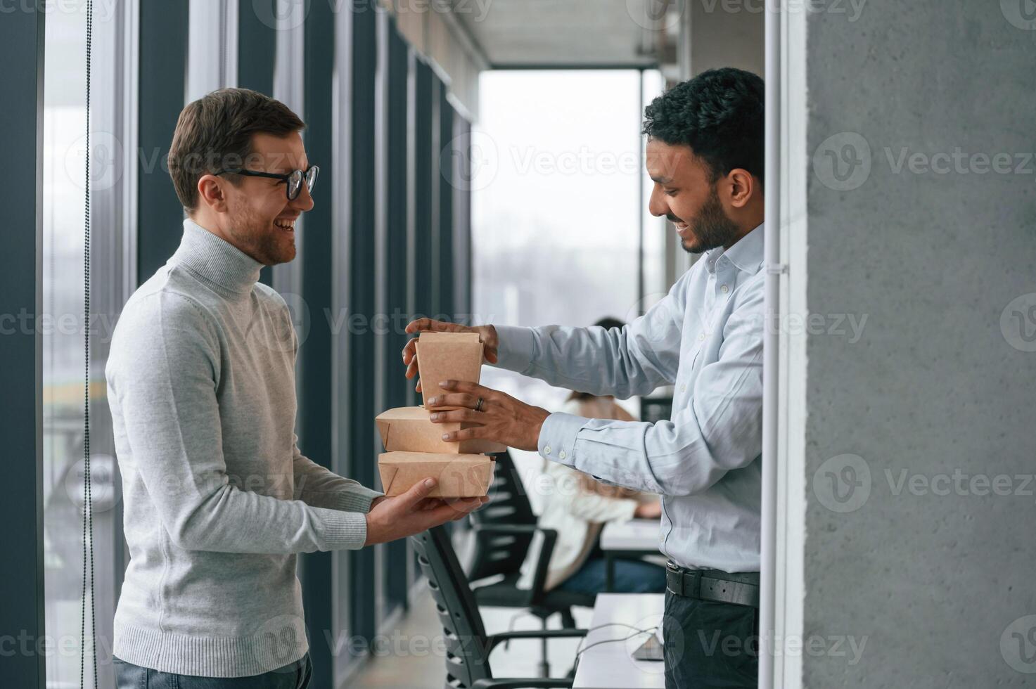 Men, are holding eco paper boxes in hands. Business people are working together in the office photo