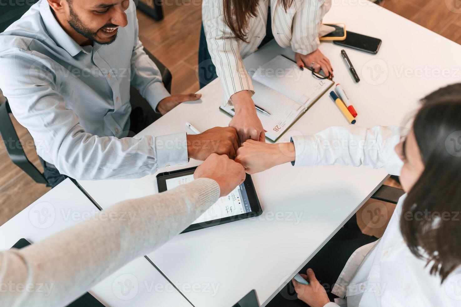Success, making hand gestures. Four ,people are working in the office together photo