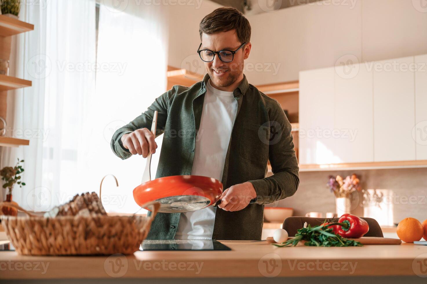 Preparing the food.. Handsome man is on the kitchen at daytime photo