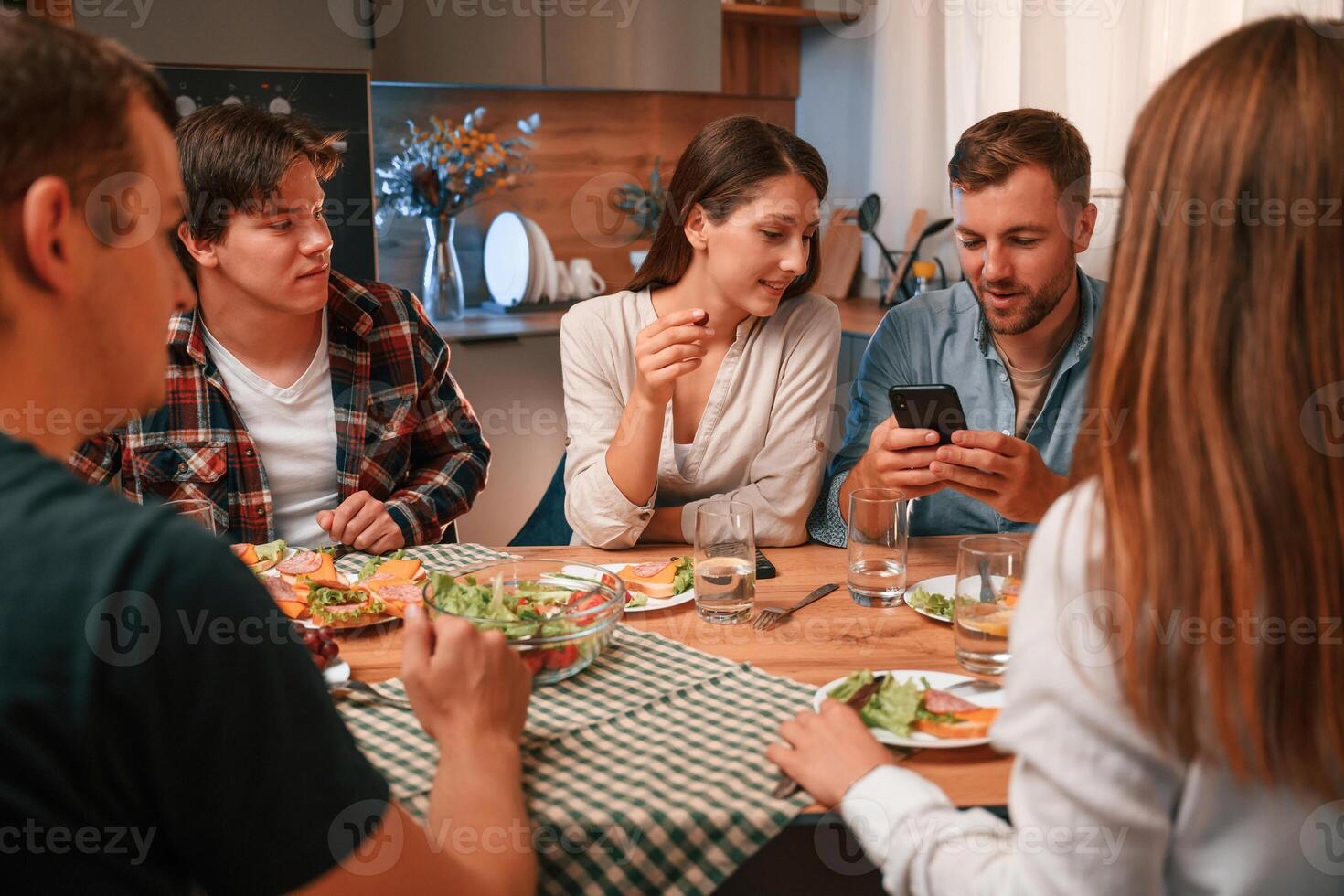 Delicious food. Group, of people are on the kitchen, having dinner, spending time together photo