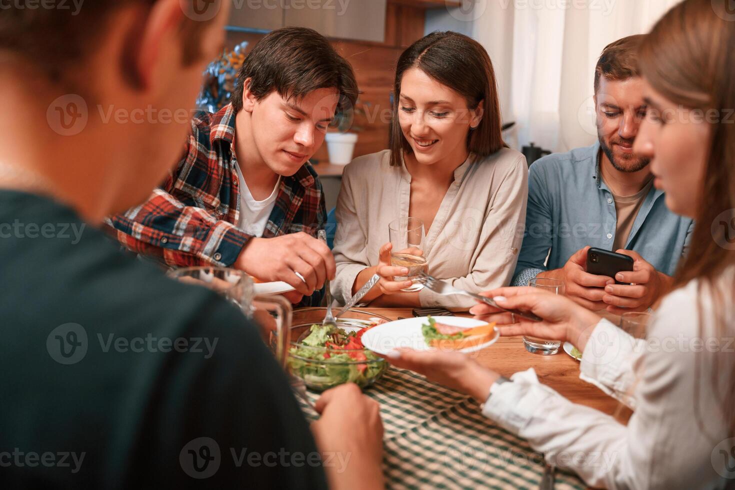 Delicious food.. Group of ,people are on the kitchen, having dinner, spending time together photo