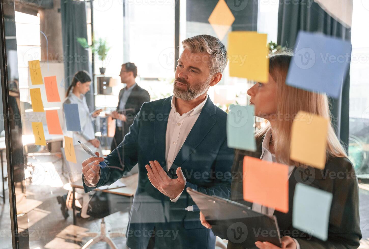 Company growth. Many stickers ,on the glass. Group of business people are working in the modern office photo