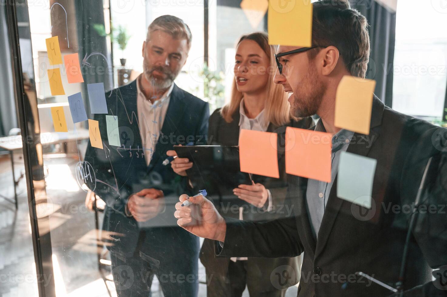 Bunch of, the stickers are on the glass. Group of business people are working in the modern office photo
