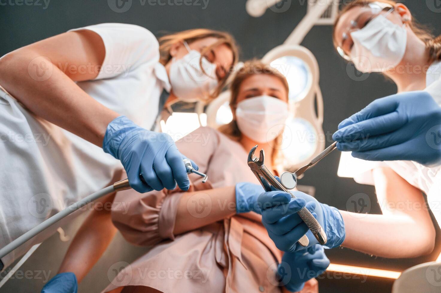 Three doctors are working.. First person view. In the stomatological cabinet photo