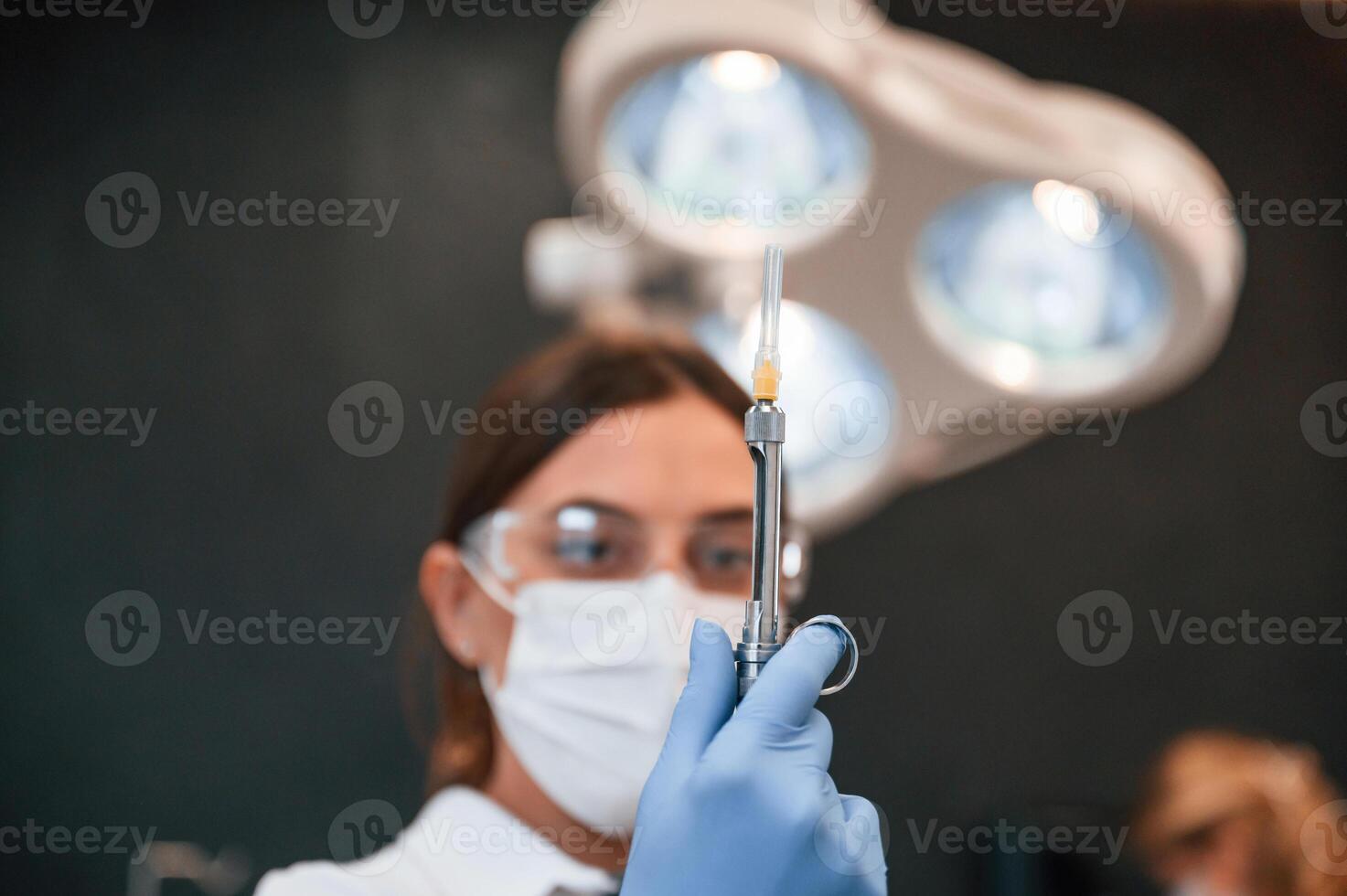 Woman holding ,syringe. In the, stomatological cabinet photo