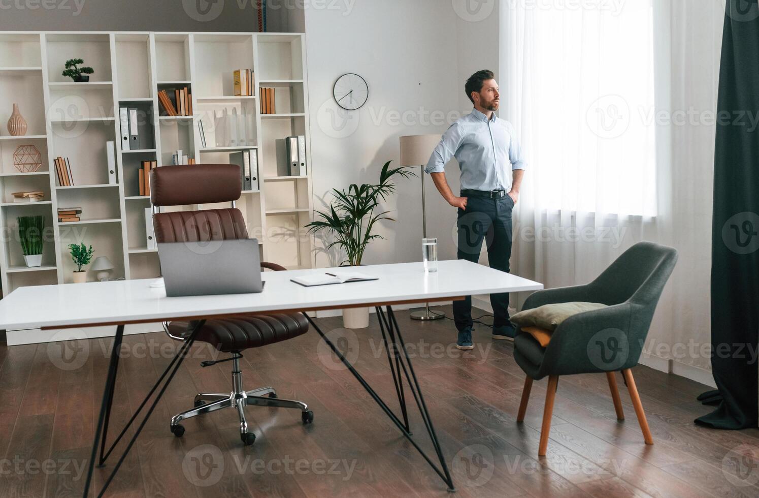 Walking,, thinking,, waiting for patient. Doctor in formal clothes is working in the cabinet photo