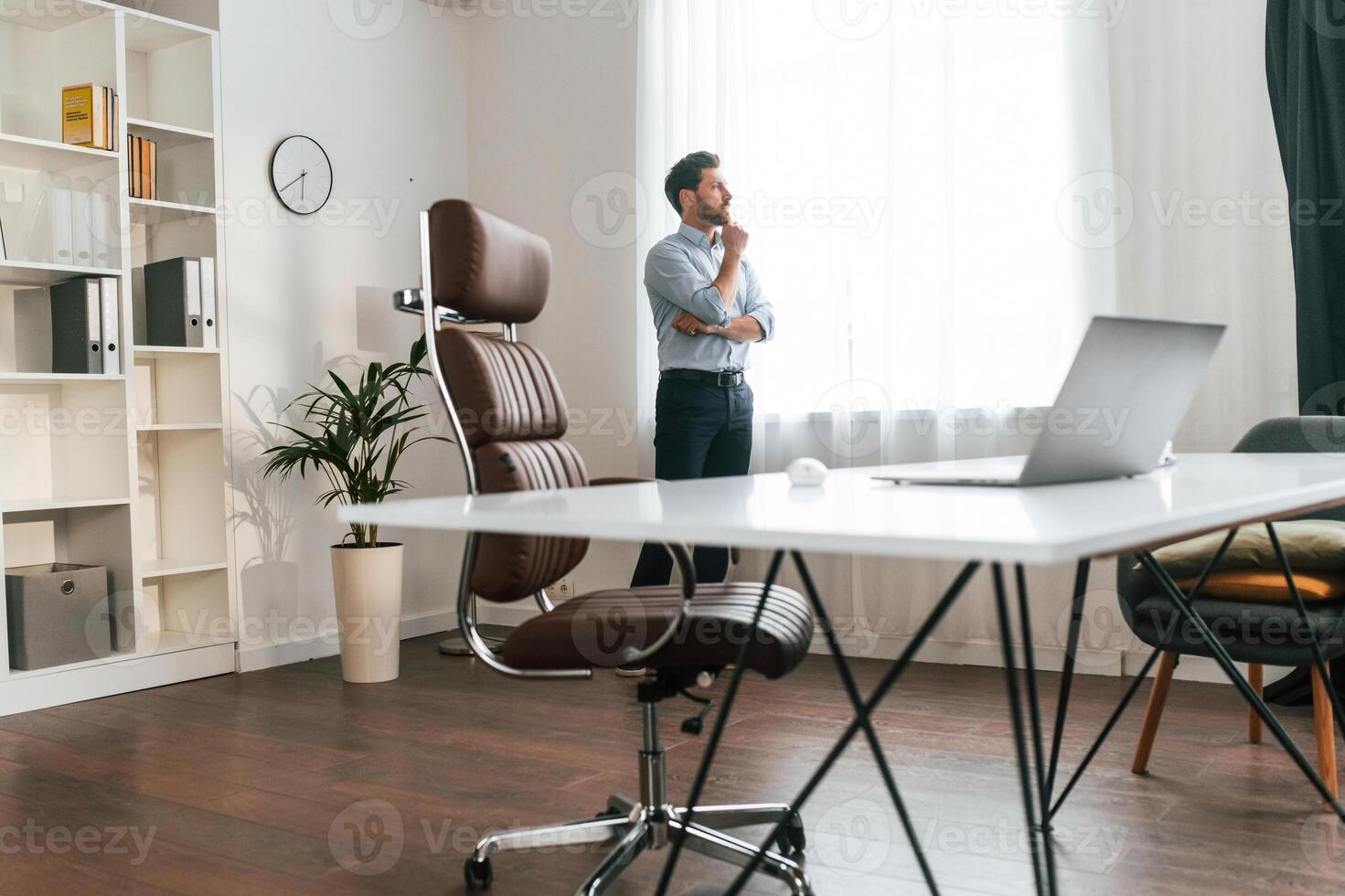 Walking, thinking, waiting for patient.. Doctor ,in formal clothes is working in the cabinet photo