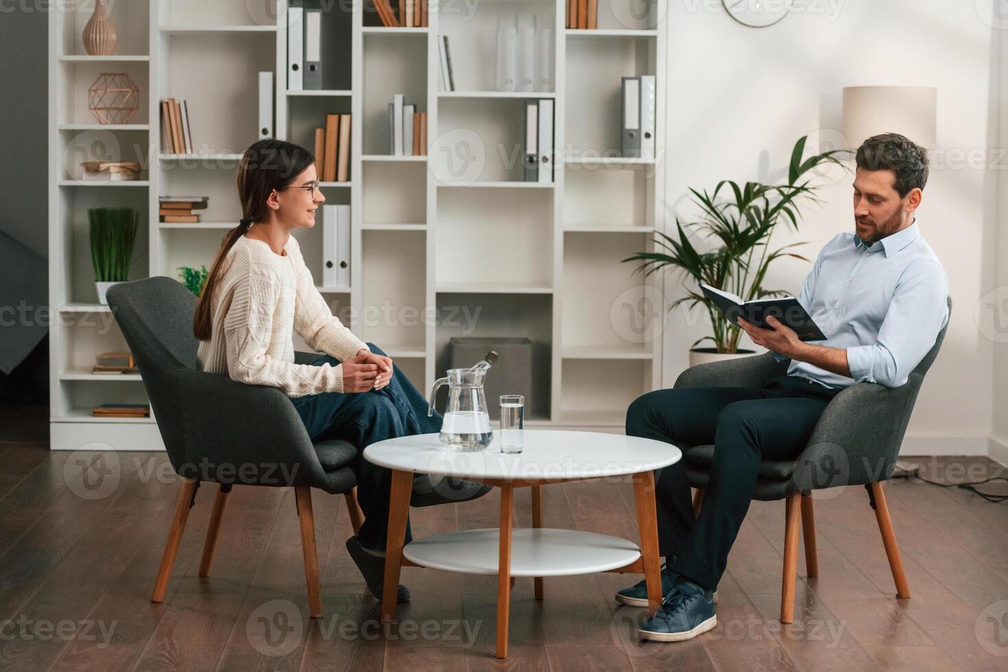 A session, with ,a ,psychologist. With woman. Doctor in formal clothes is working in the cabinet photo