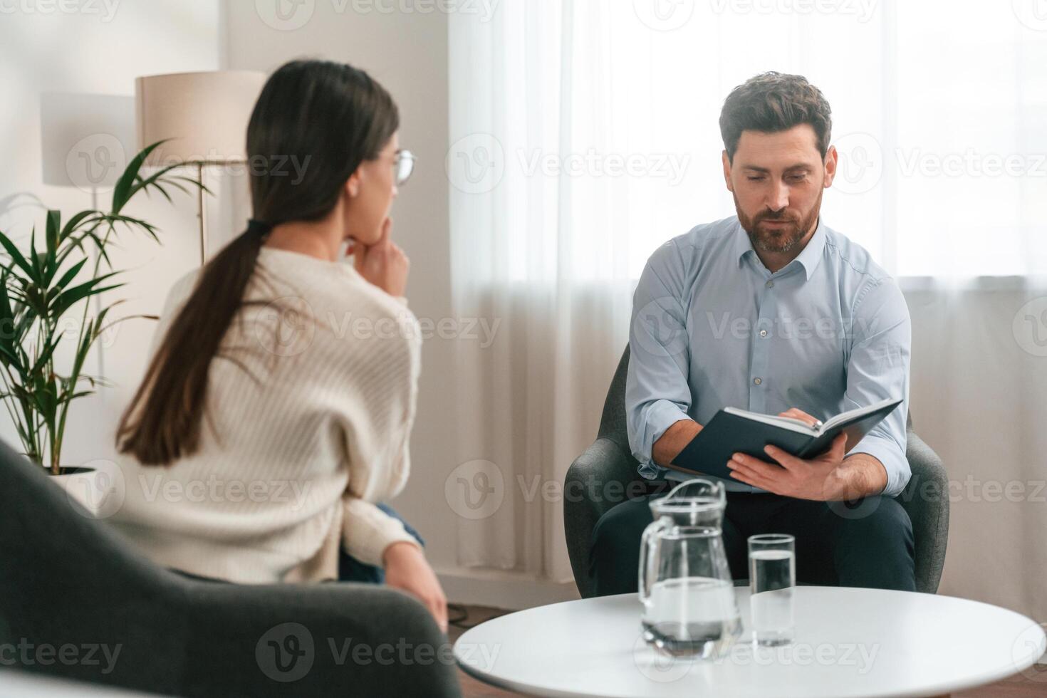 A session with ,a ,psychologist. With woman. Doctor in formal clothes is working in the cabinet photo