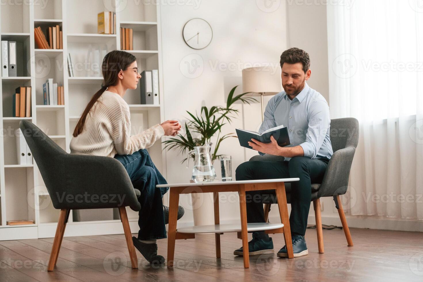A session, with ,a psychologist. With woman. Doctor in formal clothes is working in the cabinet photo