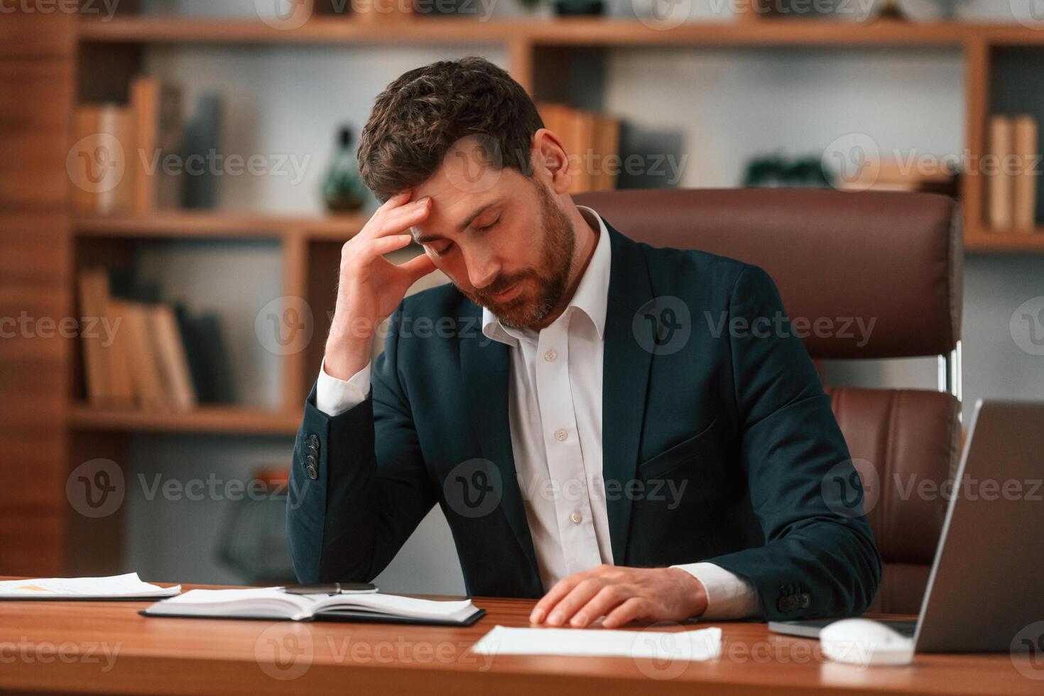 Tired, feeling bad. Businessman in ,formal ,clothes is working indoors photo