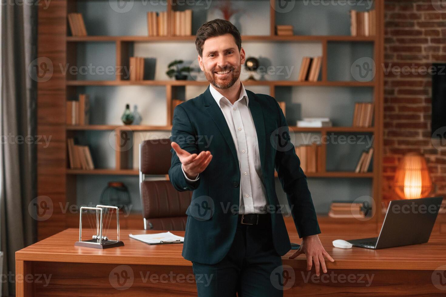 Greetings, giving the hand. Businessman in formal clothes is working indoors photo