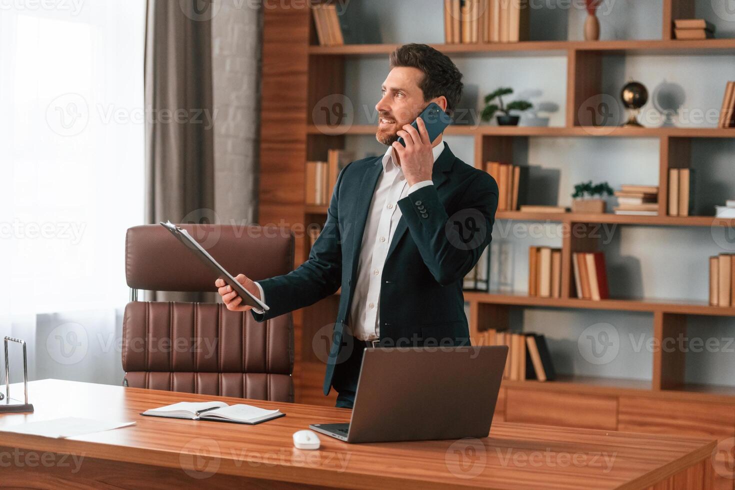 Talking, by phone. Businessman in formal clothes is working indoors photo