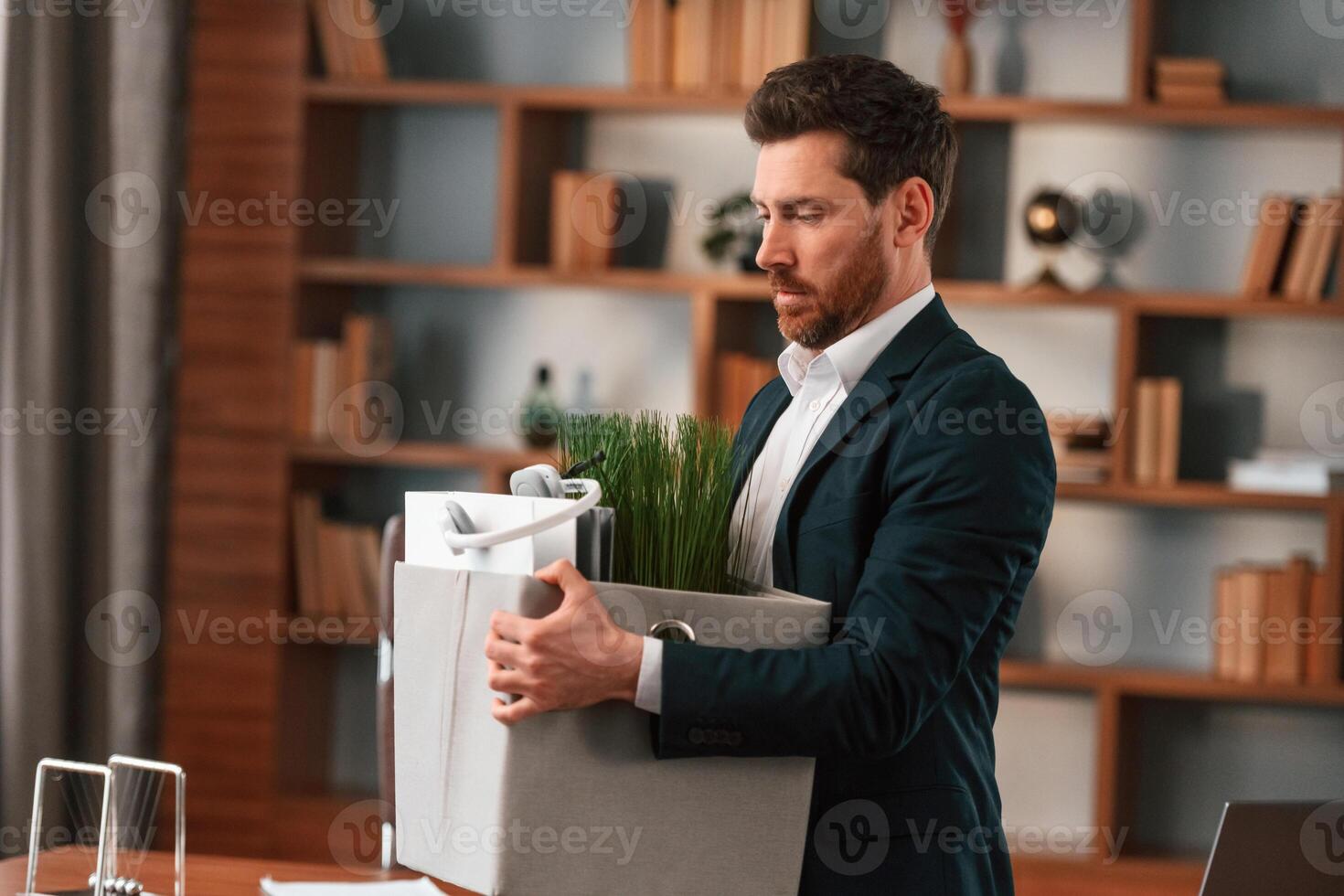With, a box of stuff in it. Businessman in formal clothes is working indoors photo
