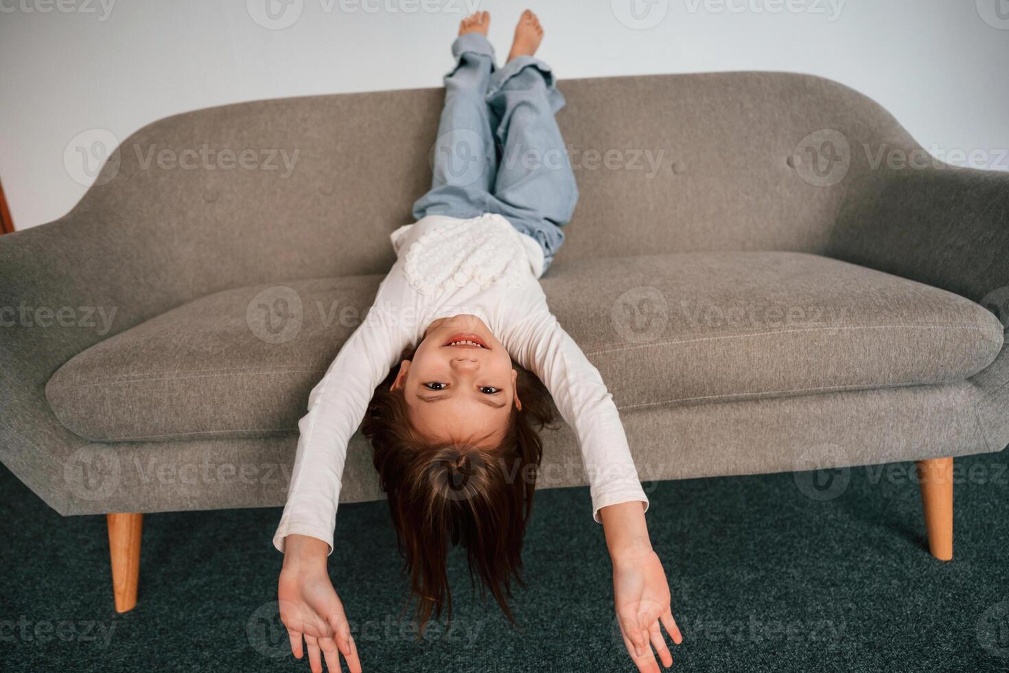 Little girl, is lying down on the sofa at home photo