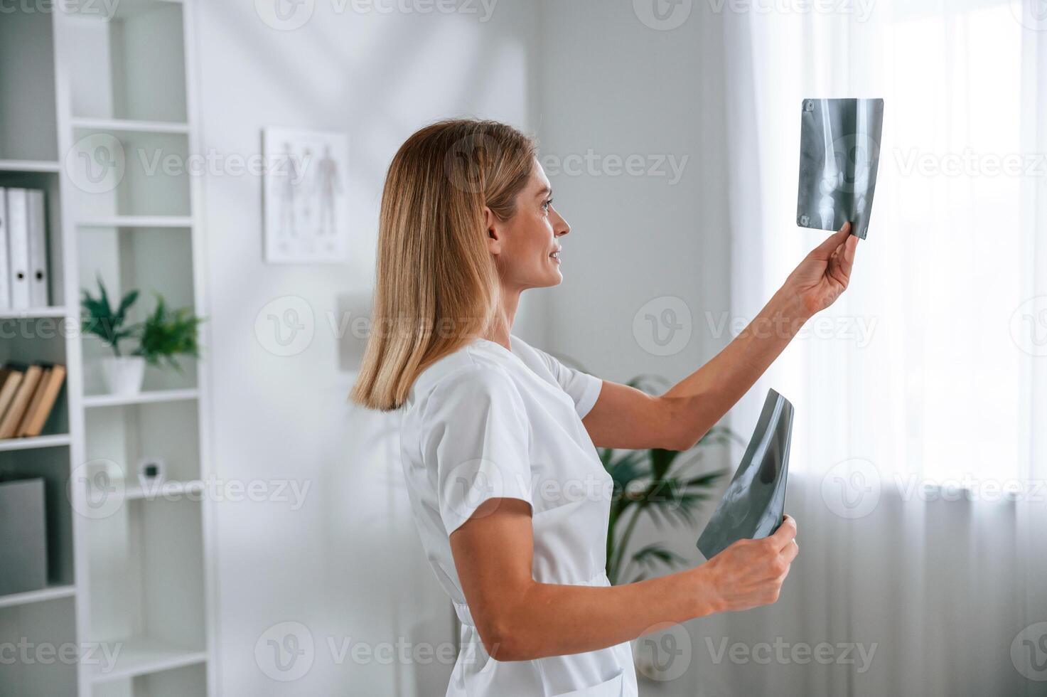Checking ,x-ray.. Young female doctor in white coat is indoors photo