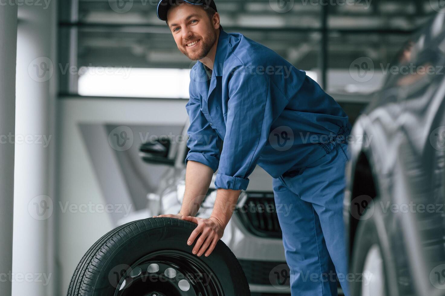 Man in blue ,uniform is working in the car service photo