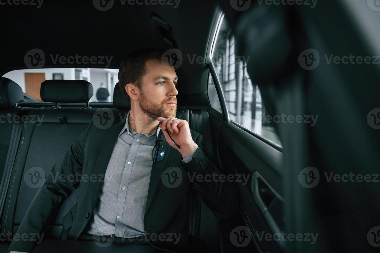 Man in formal business, clothes is sitting in the modern automobile photo