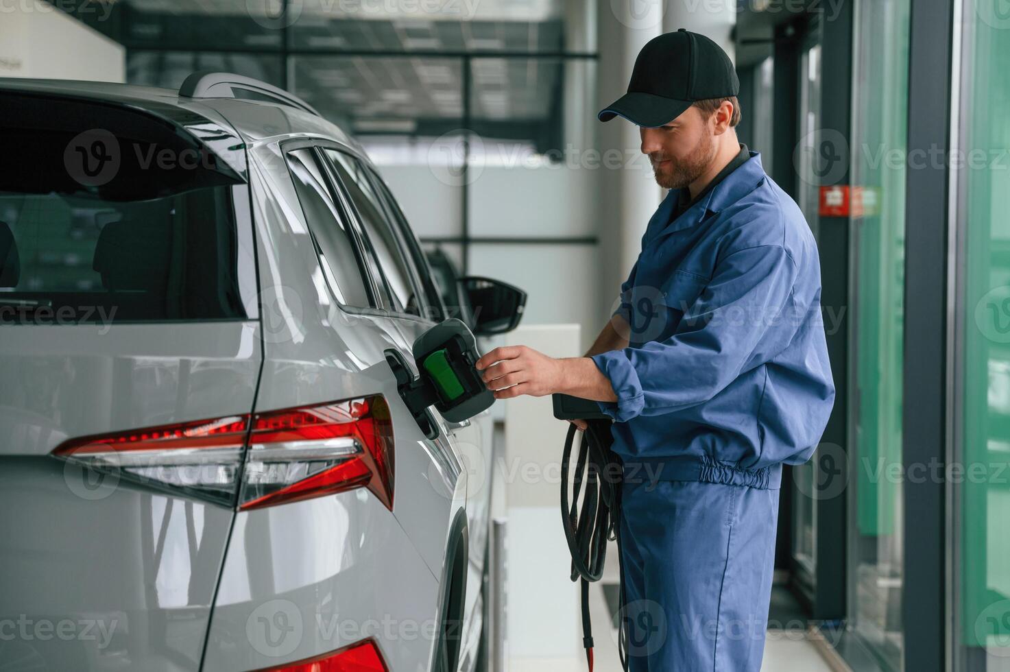 Testing the ,fuel, system. Man in blue uniform is working in the car service photo