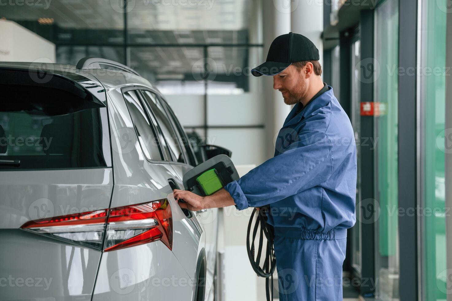 Testing, the fuel system. Man in blue uniform ,is working in the car service photo