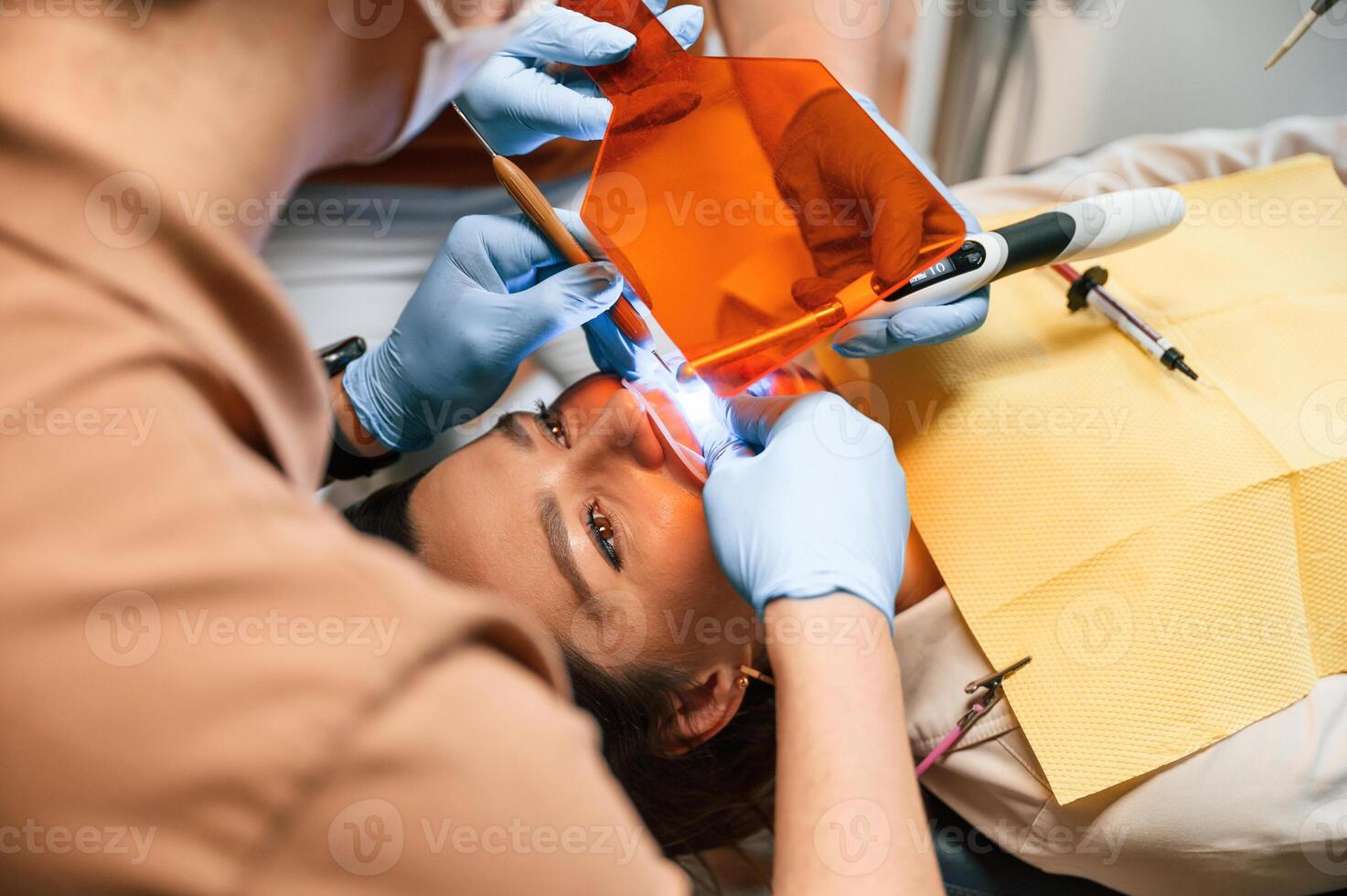 Procedure of installation of aligner in progress. Woman in the stomatology clinic, visiting dentist photo