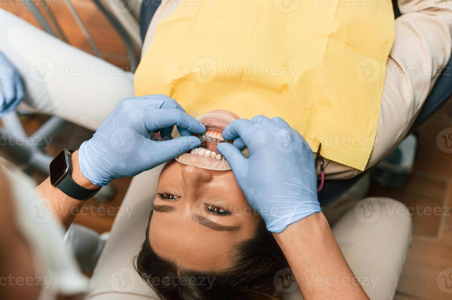 Lying on a chair.. Installation of aligner. Woman in the stomatology clinic, visiting dentist photo