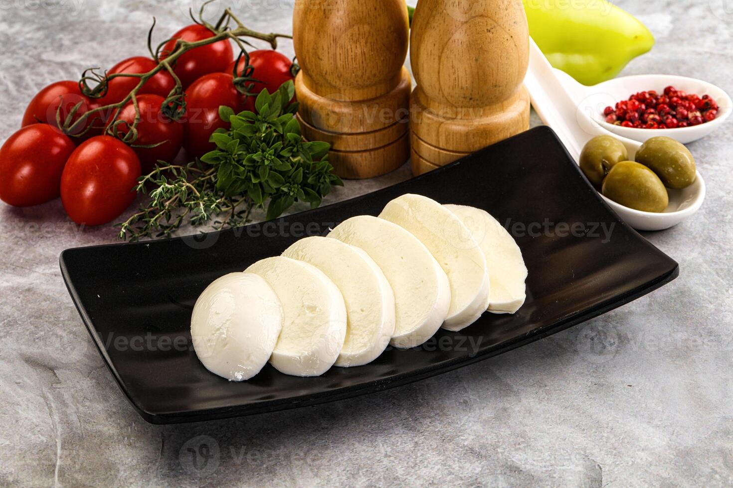A plate of cheese and other ingredients on a counter photo
