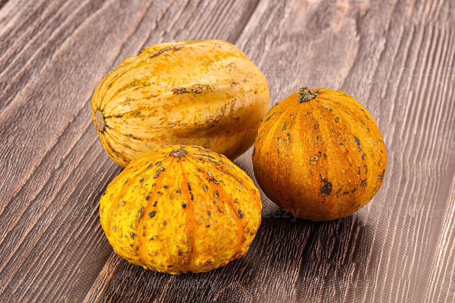 Three small squash on a wooden table photo