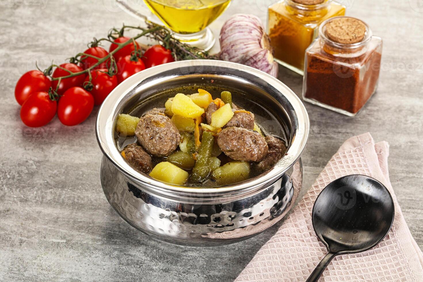 A silver pot with meat, potatoes and vegetables photo