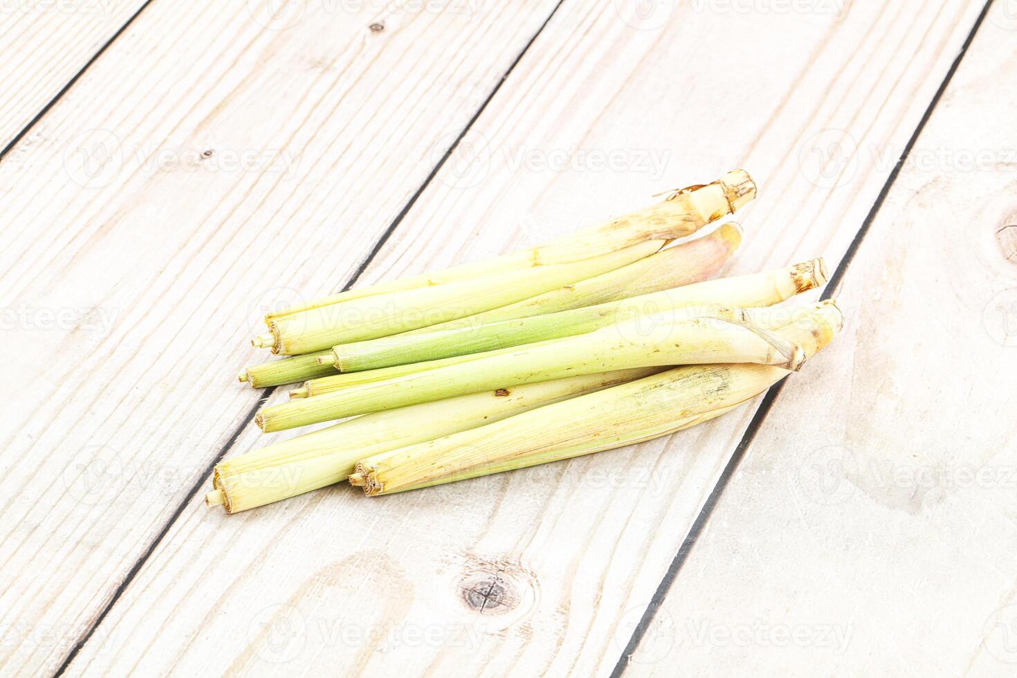 A pile of green leeks on a wooden table photo