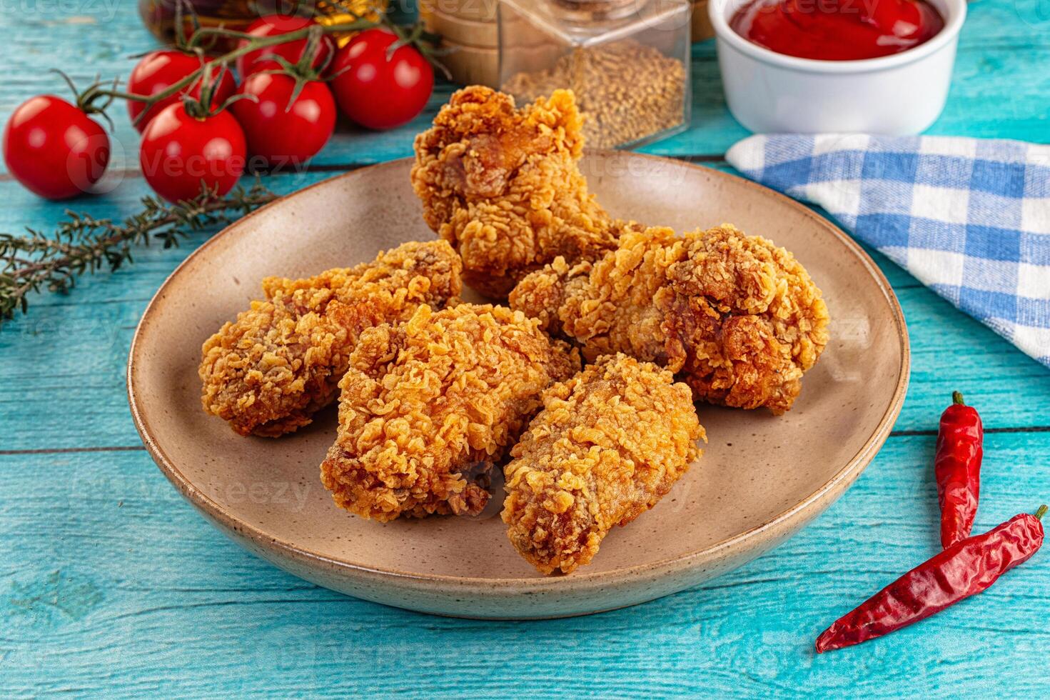 Fried chicken on a plate with ketchup and tomatoes photo