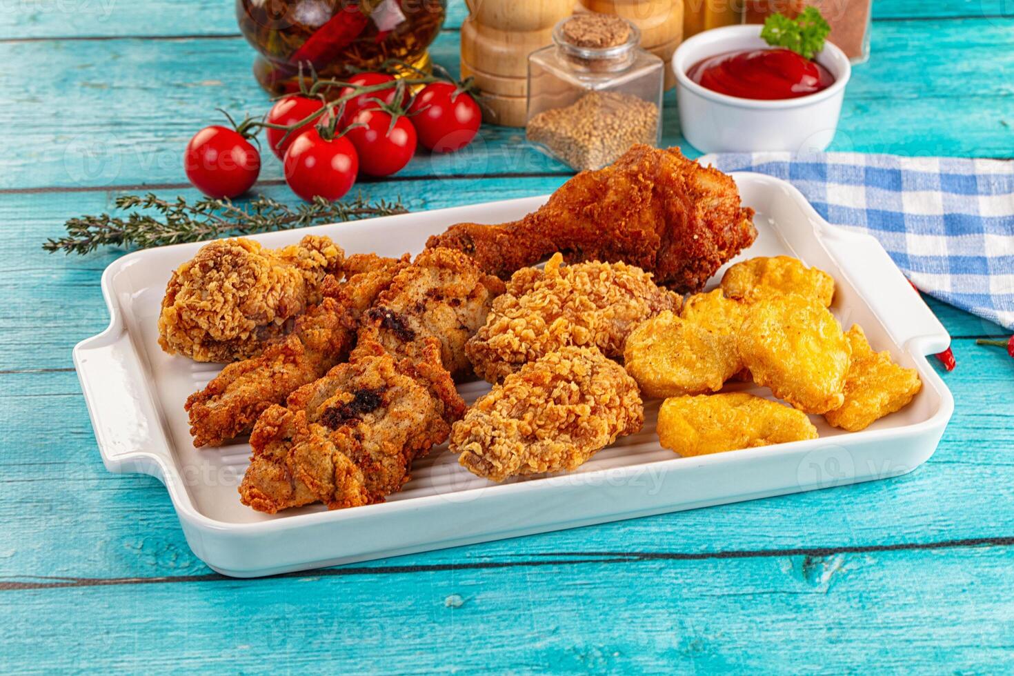 A tray of fried chicken and other food on a table photo