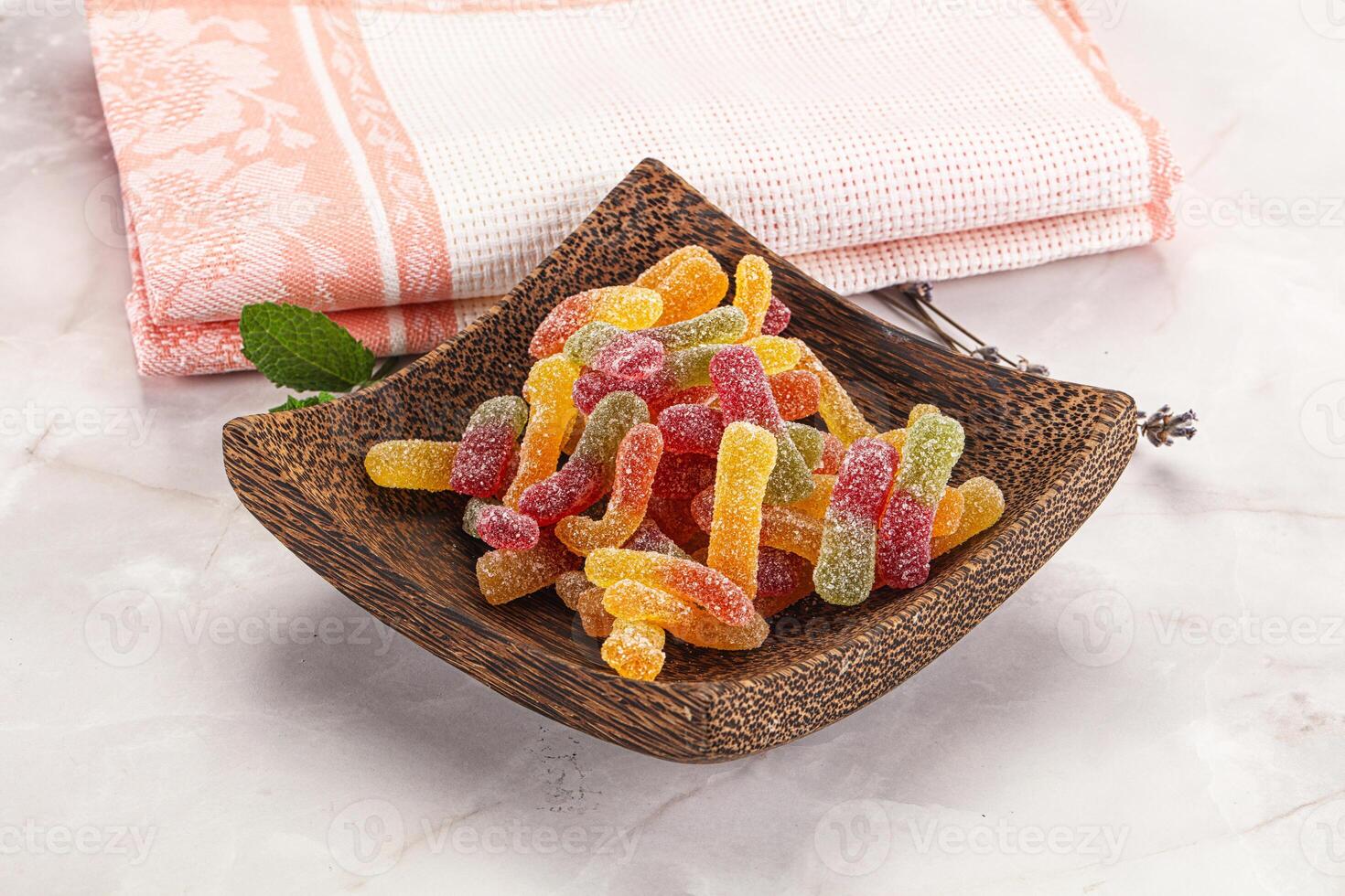 A wooden bowl with a bowl of gummy bears photo